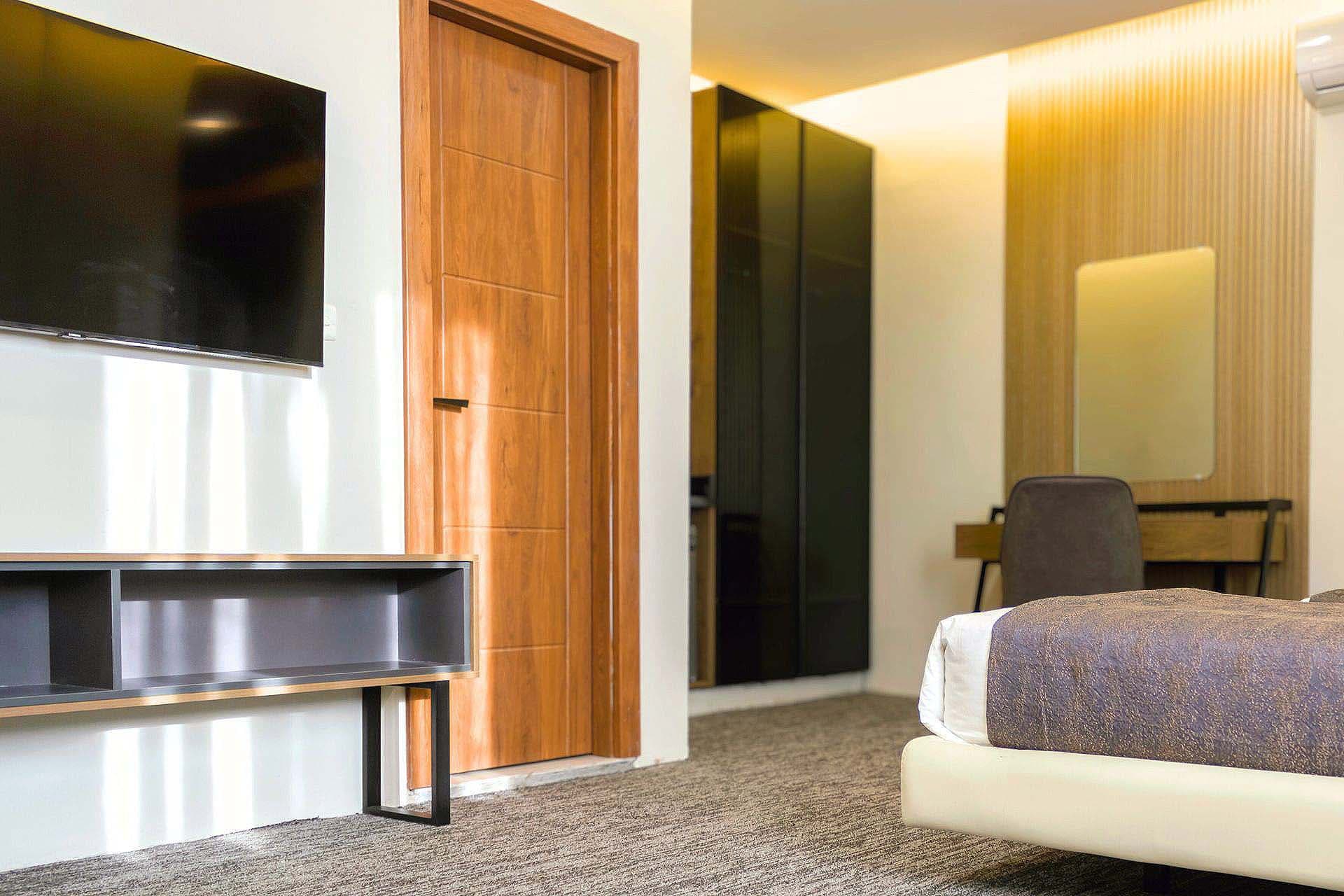 Full room view of a leork hotel room with a bed , wardrobe and study table